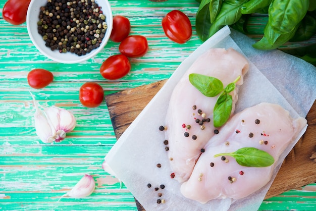 Petto di pollo crudo marinato per la cottura su una tavola di legno, messa a fuoco selettiva, spazio copia