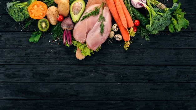 Petto di pollo e verdure fresche Cibo sano Su uno sfondo di legno nero Vista dall'alto Spazio di copia