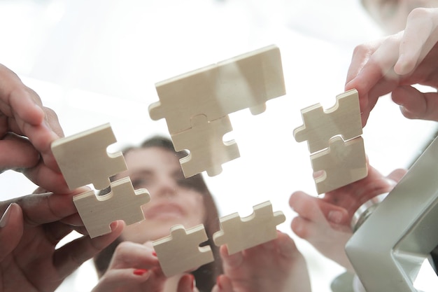 Pezzi del puzzle pieghevoli della squadra di affari di vista dal basso