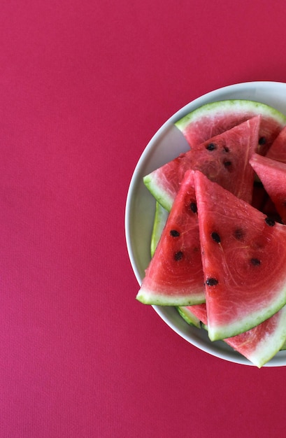 Pezzi di anguria maturi e dolci su sfondo rosso Vista dall'alto Spazio per la copia Cibo vegano estivo arricchito o vitaminizzato