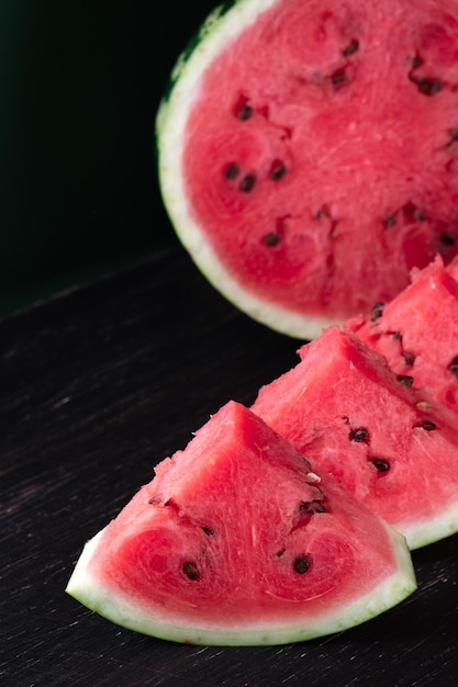 Pezzi di anguria rinfrescante su uno sfondo di legno scuro Foto del primo piano Texture di frutta