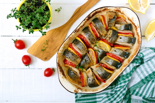 Pezzi di aringa, cipolla, pomodoro, limone, erbe aromatiche in forma di ceramica