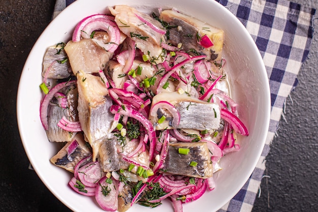 Pezzi di aringa con cipolle sottaceto pesce salato frutti di mare porzione fresca pronta da mangiare spuntino pasto