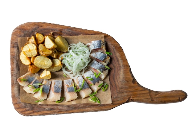 Pezzi di aringhe con cipolle e patate servite su una tavola di legno Antipasto gustoso tradizionale Primo piano Vista dall'alto Isolato su sfondo bianco