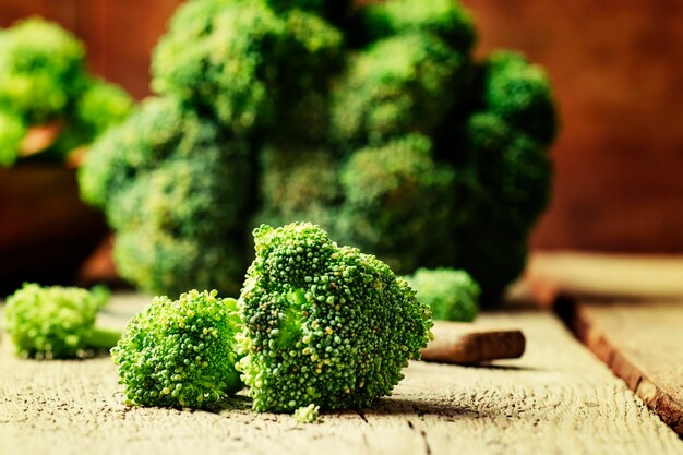 Pezzi di broccoli in stile rustico vecchio fondo di legno fuoco selettivo