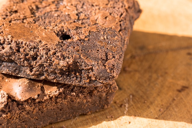 Pezzi di brownie fresco su fondo di legno. Torta al cioccolato deliziosa. Primo piano a macroistruzione. Messa a fuoco selettiva.