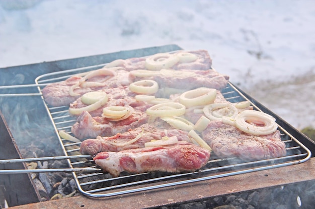 Pezzi di carne con cipolla sono cotti al barbecue Pezzi di cipolla e bistecca cotti sul fuoco