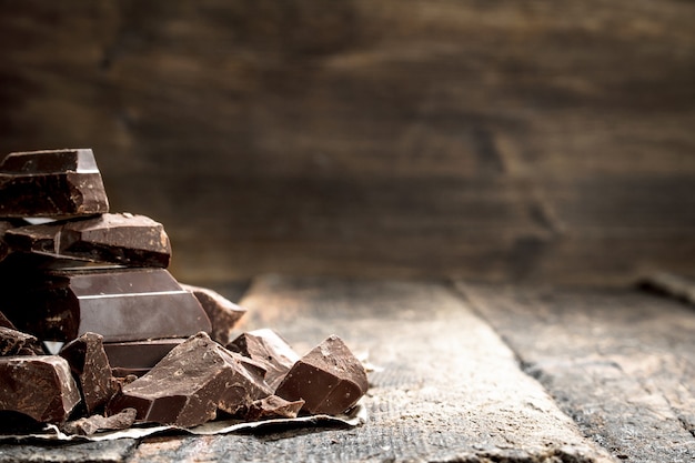 Pezzi di cioccolato fondente. Su un tavolo di legno.