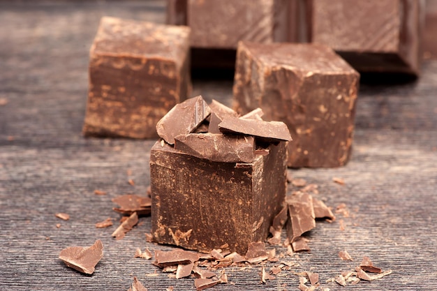 Pezzi di cioccolato fondente su uno sfondo di legno