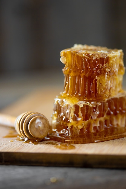Pezzi di favo fresco con miele e un bastoncino di legno