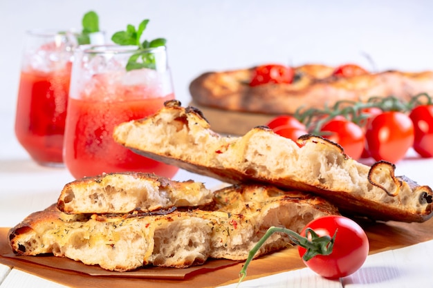 pezzi di focaccia fatta in casa con cipolle pomodori aglio e olio d'oliva concetto di cucina casalinga