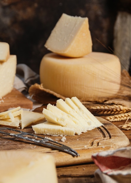 Pezzi di formaggio fresco fatto in casa su una tavola di legno con un coltello da vicino