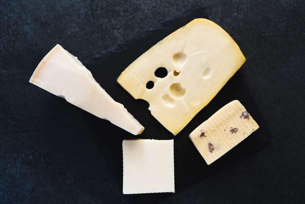 Pezzi di formaggio solido appetitoso su una banda nera