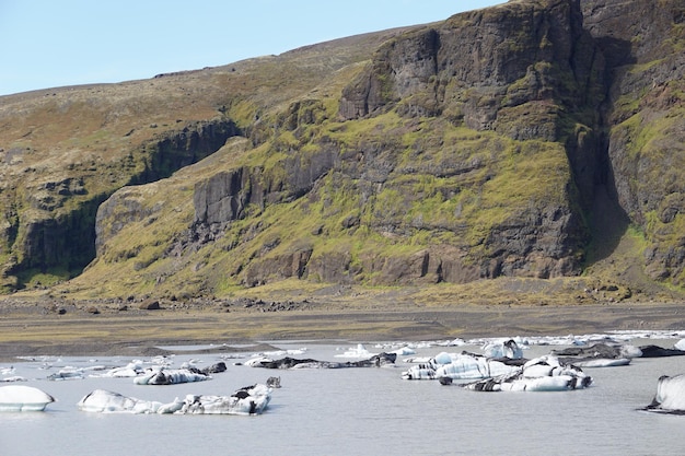 Pezzi di ghiaccio che galleggiano nel lago al ghiacciaio Solheimajokull in Islanda