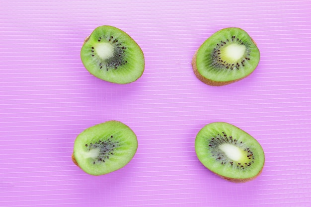 Pezzi di kiwi fresco su sfondo colorato. Kiwi su sfondo viola