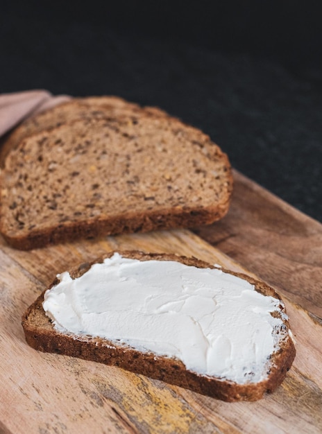 Pezzi di pane con crema di formaggio su una tavola sul tavolo