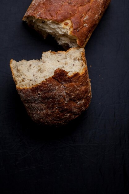 Pezzi di pane con crusca e semi, su fondo scuro. Foto ravvicinata, messa a fuoco morbida. Cibo salutare.