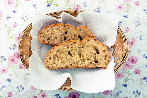 Pezzi di pane di grano ricco in un cesto di vimini sul tavolo