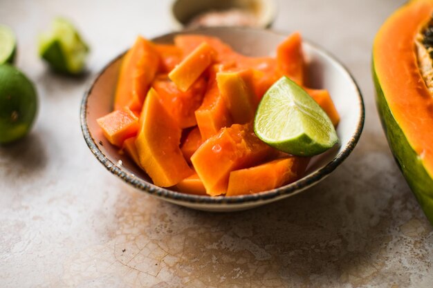 Pezzi di papaya con lime e sale su piatto per cucinare cibo