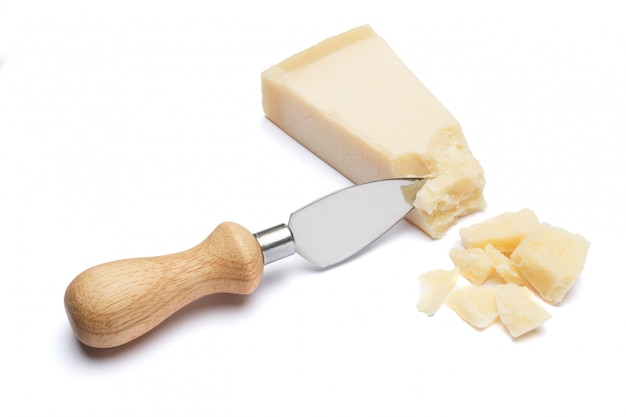 Pezzi di parmigiano e coltello sulla tavola bianca