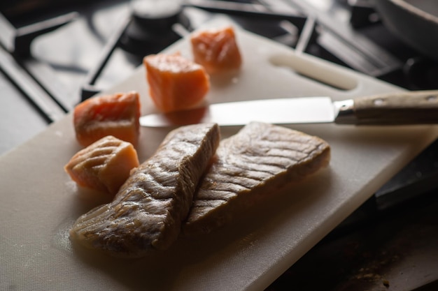 Pezzi di pesce bianco e rosso su un tagliere Preparazione per la cottura