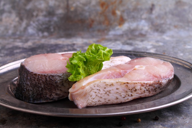 Pezzi di pesce crudo bianco su uno sfondo di metallo