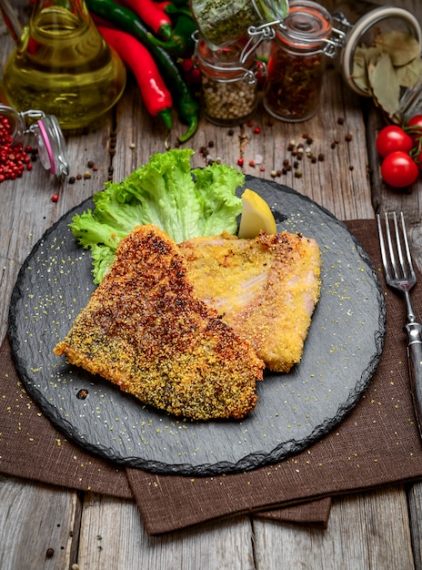 Pezzi di pesce fritto, carpe, su piatto di ceramica