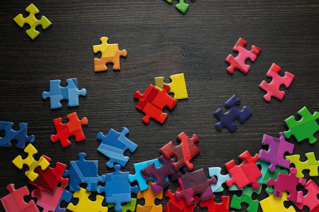 Pezzi di puzzle multicolori su sfondo nero Concetto di giornata mondiale dell'autismo