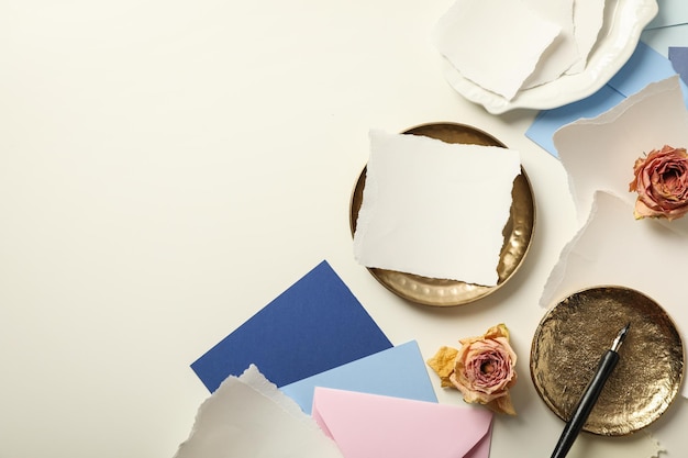 Pezzi di rose di carta e lastre d'oro su sfondo bianco spazio per il testo