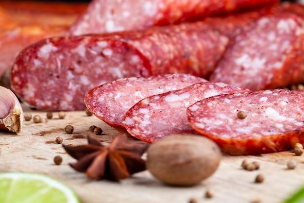 Pezzi di salsiccia affettati di carne giacciono su un tagliere la carne di maiale con pancetta viene essiccata e appassita la carne è pronta per essere mangiata