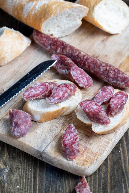 Pezzi di salsiccia affettati di carne giacciono su un tagliere la carne di maiale con pancetta viene essiccata e appassita la carne è pronta per essere mangiata