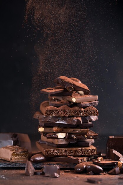 Pezzi di torretta di cioccolato Pezzi scuri di nocciola e mandorle di cioccolato rotto Concetto di foto di cibi dolci