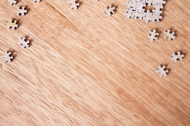 Pezzi di un puzzle in bianco sulla tavola di legno