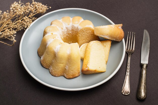 Pezzi di una torta ciambella su un piatto grigio su un tavolo con una tovaglia grigia