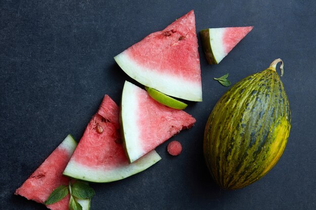 Pezzi freschi di anguria e melone su uno sfondo nero