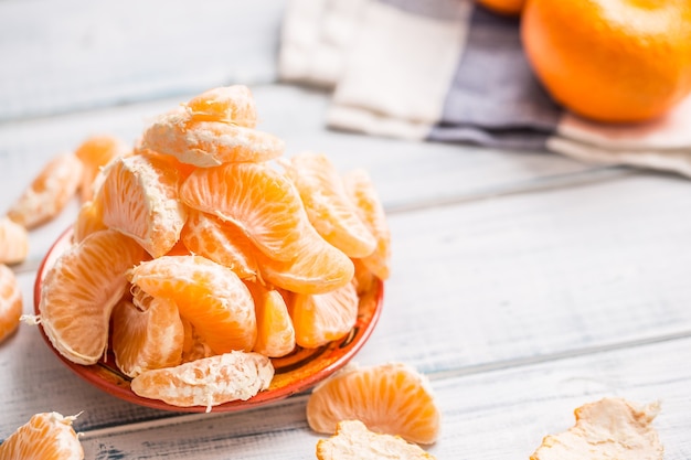Pezzi freschi di mandarini mandarini sul piatto o in una ciotola.