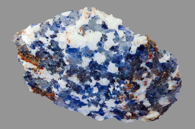 Pezzo bianco e blu di minerale di salgemma, salgemma cristallino naturale, isolato su sfondo grigio