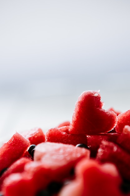 Pezzo di anguria e cuori a sfondo bianco