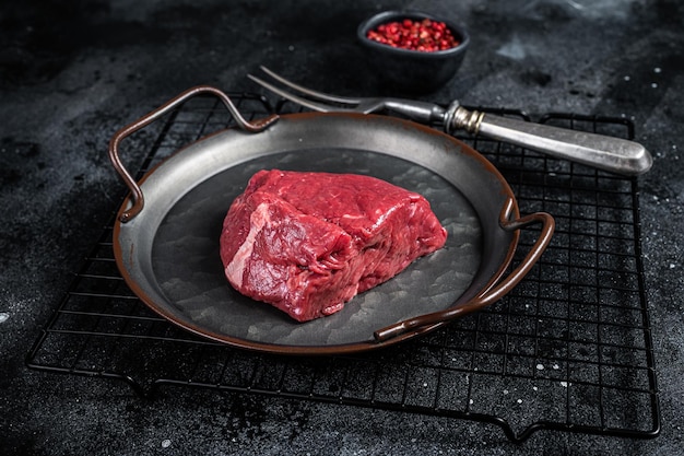 Pezzo di bistecca cruda preparata per la cottura Sfondo nero Vista dall'alto