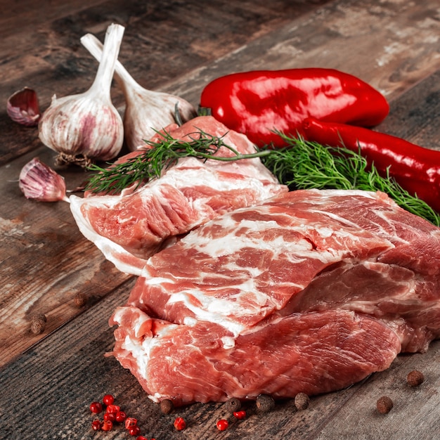 Pezzo di carne cruda pronto per la preparazione con verdure e spezie