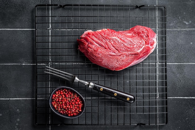 Pezzo di carne di manzo crudo per grigliare con spezie Sfondo nero Vista dall'alto