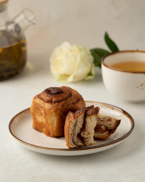 Pezzo di cruffin e tazza di rose bianche da tè