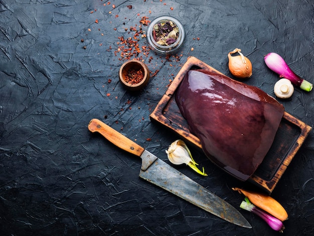 Pezzo di fegato di manzo crudo sul tagliere della cucina