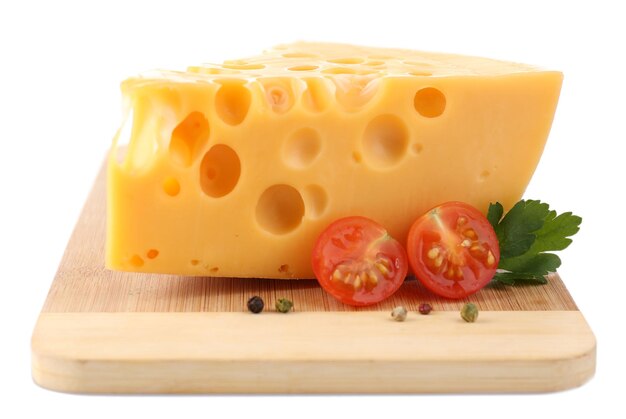 Pezzo di formaggio e pomodori su tavola di legno isolato su bianco