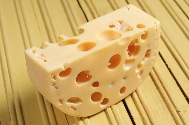 Pezzo di formaggio su fondo di legno giallo