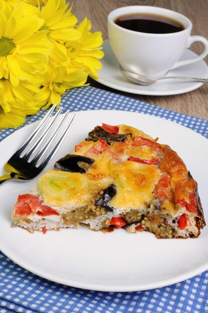 Pezzo di frittata di melanzane, porri, pomodori e pepe con formaggio