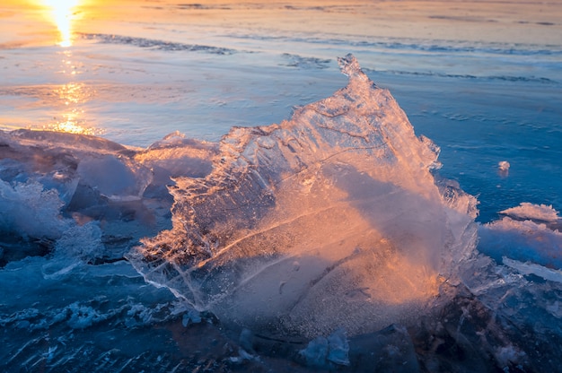 Pezzo di ghiaccio trasparente sul lago ghiacciato al tramonto