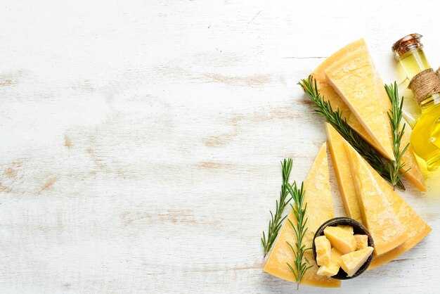 Pezzo di parmigiano su uno sfondo di legno bianco Formaggio tradizionale italiano Vista dall'alto Spazio libero per il testo