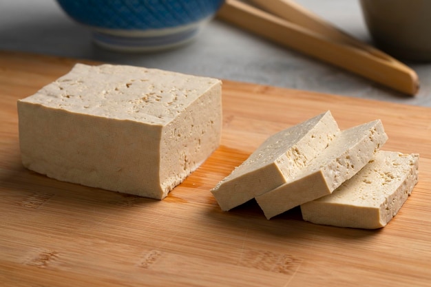 Pezzo di tofu fresco e fette su un tagliere