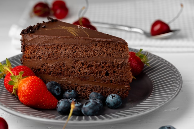 Pezzo di torta al cioccolato servito con frutti di bosco freschi